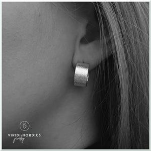 women model with small shiny silver hoop earring
